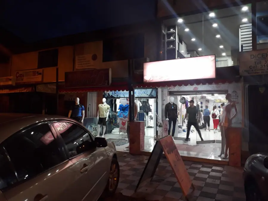 Fachada de El Huequito de la 80 de noche, con maniquíes en la entrada